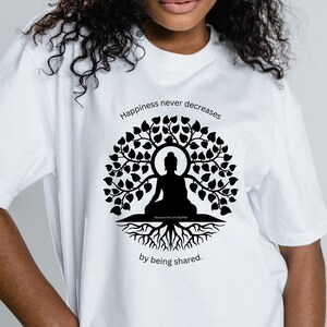 Peut inclure: Un t-shirt blanc avec une silhouette noire d'un Bouddha méditant dans un arbre avec le texte "Le bonheur ne diminue jamais en étant partagé."