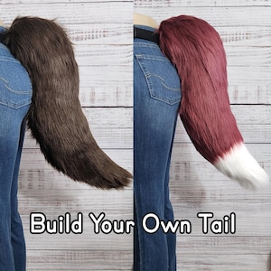 May include: Two people wearing jeans and a belt with a furry tail attached to the back of their waist. The tail on the left is brown and the tail on the right is red with a white tip. The text "Build Your Own Tail" is at the bottom of the image.