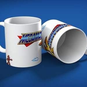 May include: Two white ceramic mugs with the "MEGAMAN" logo in blue, yellow, and red. One mug is upright, the other is tilted. A small character graphic and water effect are also visible on the mug.