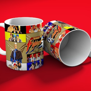 May include: White ceramic mug featuring a colorful design from "The King of Fighters" video game series. The design includes various characters and the game's logo. The mug is set against a red background.