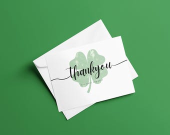 May include: A white card with a green four-leaf clover graphic and the text "thank you for your support".
