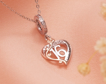 Puede incluir: Un collar plateado con un colgante en forma de corazón. El colgante presenta el número "16" en el centro, rodeado por un contorno de corazón con pequeñas piedras transparentes. Las palabras "Love You Forever" están inscritas en el corazón.
