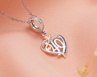 Puede incluir: Un collar plateado con un colgante en forma de corazón. El colgante presenta una rosa y el número 40 en dorado, con las palabras "Love You Forever" grabadas. El colgante está adornado con pequeñas piedras transparentes.
