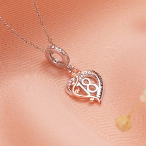 Peut inclure: Un collier argenté avec un pendentif en forme de cœur. Le pendentif porte le chiffre 18, une rose et l'inscription « Love You Forever ». Le pendentif est orné de cristaux transparents et est suspendu à une chaîne délicate.