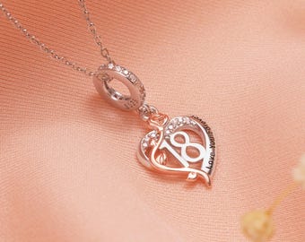 May include: A silver necklace with a heart-shaped pendant. The pendant features the number 18, a rose, and the words "Love You Forever". The pendant is accented with clear crystals and hangs from a delicate chain.