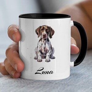 May include: White ceramic mug with a black interior and handle. The mug features a watercolor illustration of a brown and white dog with the name "Luna" in script. The dog is sitting upright.