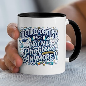 May include: White ceramic mug with a black interior and handle. The mug features a colourful design with the words "Retired Dentist 2026 Not My Problem Anymore!" along with dental-themed illustrations. A hand is holding the mug.