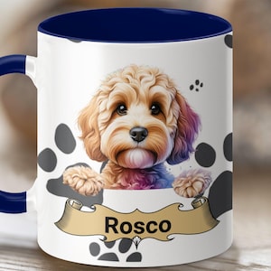 May include: White ceramic coffee mug with a blue rim and handle. The mug features a cartoon illustration of a brown and white dog with the name "Rosco" on a banner.