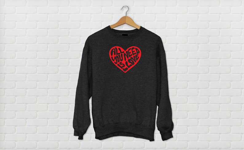May include: A dark gray sweatshirt with a red heart graphic that says "All You Need Is Love" in a stylized font.