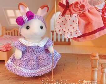May include: A crochet pattern for a purple dress with white trim for a small doll. The doll is a white rabbit with brown ears and a purple headband with a bow. The dress is hanging on a clothesline with other doll clothes.