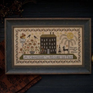 May include: A framed cross-stitch sampler with a spooky house, a witch, a black cat, and a horse. The sampler is titled "A Ghoultide Welcome to Thee" and is signed "This work wrought by me F.Stewart".