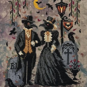 May include: A cross-stitch embroidery on mottled fabric featuring two figures in plague doctor masks and Victorian attire. The scene includes a yellow crescent moon, bats, a street lamp, tombstones with crosses, and ravens. The text mrwebbak is visible.
