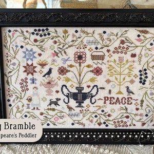 May include: A framed cross-stitch sampler with a black frame, featuring a floral and bird design in various colors. The word "PEACE" is stitched in the center. The text "Spring Bramble by Shakespeare's Peddler" is at the bottom.