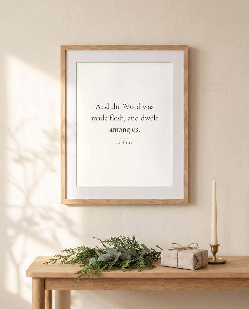 Peut inclure: Une affiche murale rectangulaire dans un cadre en bois clair avec le texte noir : And the Word was made flesh, and dwelt among us. JOHN 1:14. L'affiche est centr&eacute;e sur un mur uni, accompagn&eacute;e d'un petit cadeau et d'une bougie.