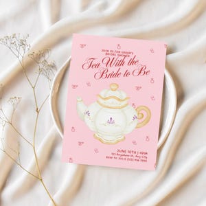 May include: A pink bridal shower invitation card with the text "Tea With the Bride to Be". It features a teapot illustration and event details: June 10th, 4 PM. The card also includes RSVP information.