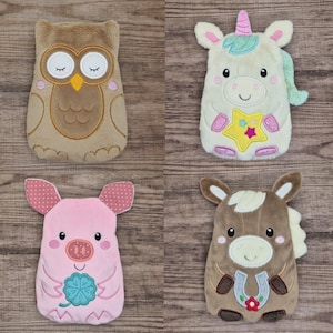 Könnte beinhalten: Vier Plüschtierspielzeuge: eine Eule, ein Einhorn, ein Schwein und ein Pferd. Die Eule ist braun mit geschlossenen Augen. Das Einhorn ist weiß mit einem rosa Horn und einem Stern. Das Schwein ist rosa mit gepunkteten Ohren. Das Pferd ist braun mit einem Hufeisen.