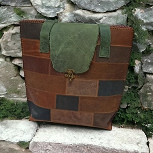 Può includere: Una borsa tote in pelle marrone patchwork con una patta in tela verde e una chiusura in ottone. La borsa ha un aspetto unico e fatto a mano ed è perfetta per trasportare gli oggetti essenziali di tutti i giorni.