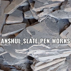 以下が含まれることがあります： 灰色と黒の頁岩の石板の山。画像には「ANSHUL_SLATE_PEN_WORKS」と「BLACK SHALE STONE」のテキストが表示されています。
