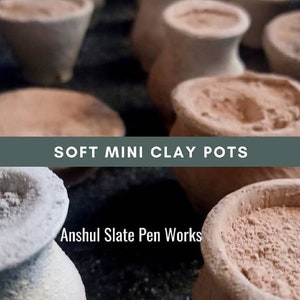 May include: A close-up of several small, terracotta clay pots. The pots are unglazed and have a rough, textured surface. The pots are filled with a light brown powder. The text "SOFT MINI CLAY POTS" is displayed above the pots. The text "Anshul Slate Pen Works" is displayed below the pots.