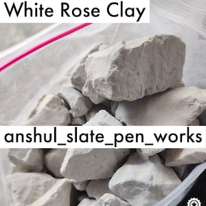 Könnte beinhalten: Nahaufnahme einer Tüte mit weißem Rosen-Ton. Der Ton ist in kleinen, unregelmäßigen Stücken. Die Tüte ist mit "White Rose Clay" und "anshul_slate_pen_works" beschriftet. Im unteren rechten Eck ist eine silberne Sterne-Auszeichnung mit den Worten "Silver", "rose" und "clay" darunter zu sehen.