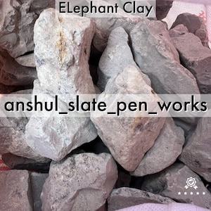 May include: A close-up of a pile of gray elephant clay, a type of pottery clay. The clay is rough and textured, and the image is labeled "Elephant Clay" and "anshul_slate_pen_works".