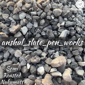 May include: A close-up of a pile of small, gray and black rocks. The text "anshul_slate_pen_works" is written across the image. The text "Semi Roasted Nakumatt" is written below the rocks.