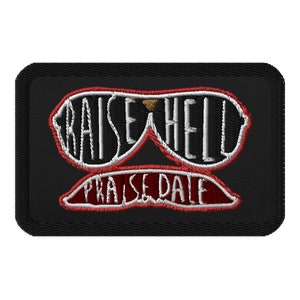 May include: Black embroidered patch with red and white stitching. The patch features a pair of sunglasses with the words "Raise Hell" and "Praise Dale" written on them.