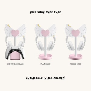May include: Three different types of pink and white headphone stands with a cute angel wing design. The stands have a controller base, a plain base, and a ribbed base. "Pick your base type" and "Available in all colors!" are written in black text.