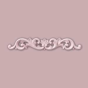 May include: A pale pink decorative moulding featuring a symmetrical design of swirling leaves and scrolls. The moulding is set against a matching pink background, creating a seamless and elegant look. This decorative element is suitable for interior design projects.