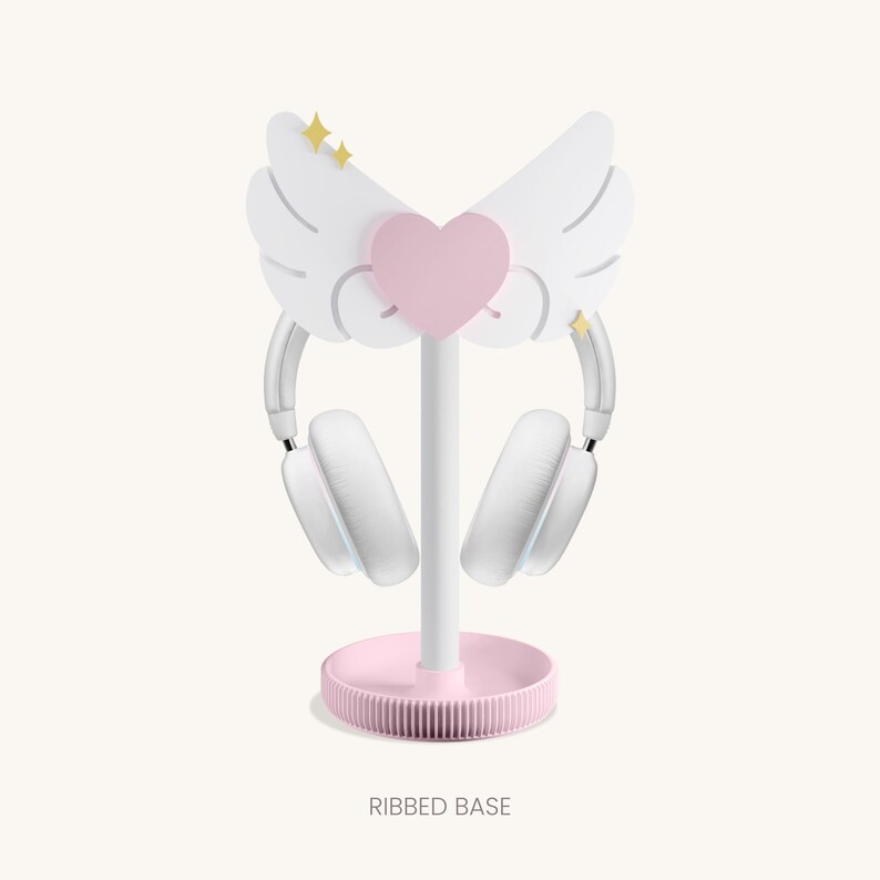 May include: White headphone stand with a pink heart and wings. The base is pink and has a ribbed design. The stand is called "RIBBED BASE".