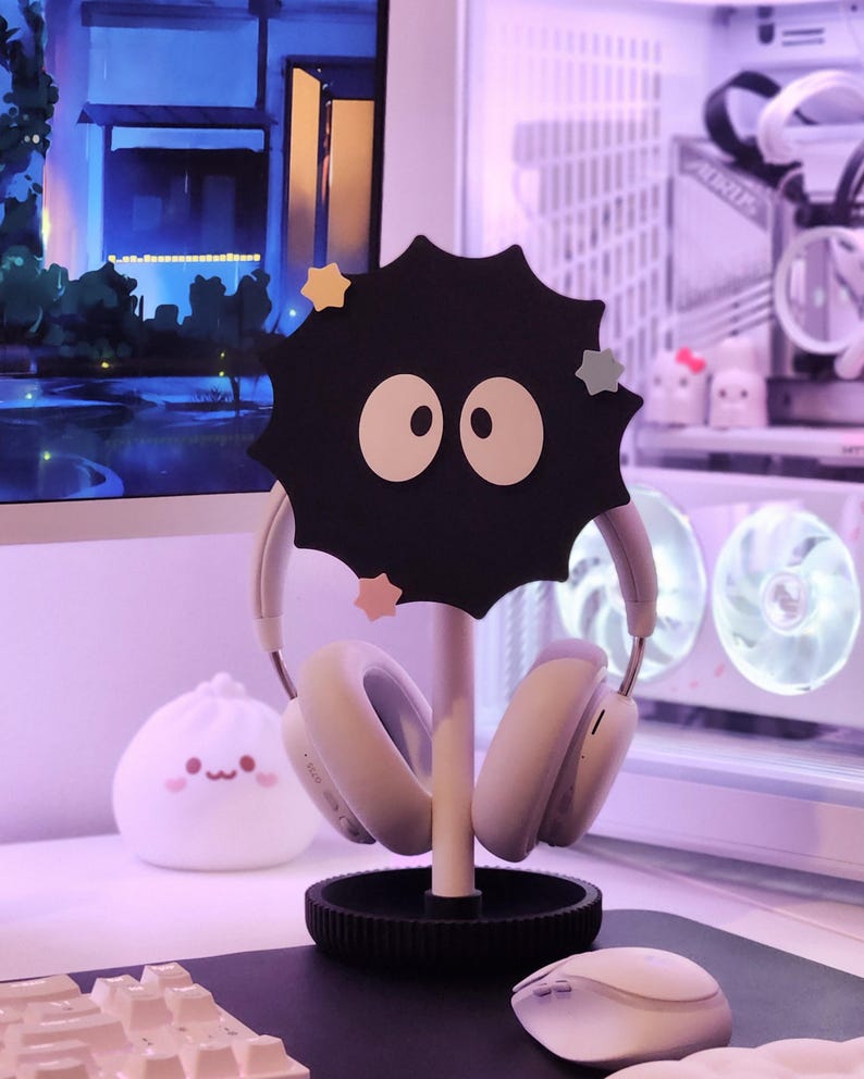 May include: A black headphone stand in the shape of a soot sprite, with white eyes and star decorations. It holds white headphones. A white mouse and a dumpling-shaped lamp are also visible.