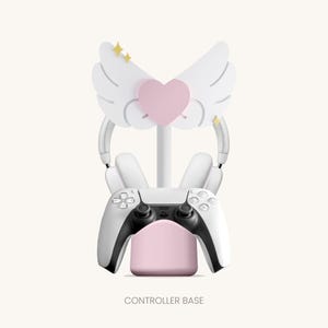 May include: White controller stand with a pink base and a white headset stand. The headset stand has a pink heart and white wings with gold stars.