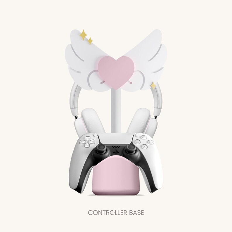 May include: White controller stand with a pink base and a white headset stand. The headset stand has a pink heart and white wings with gold stars.