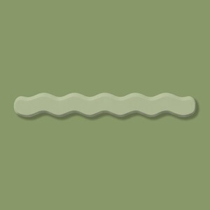May include: A sage green, wavy-shaped hair clip. The clip has a matte finish and a subtle shadow, creating a three-dimensional effect. The background is a matching sage green.