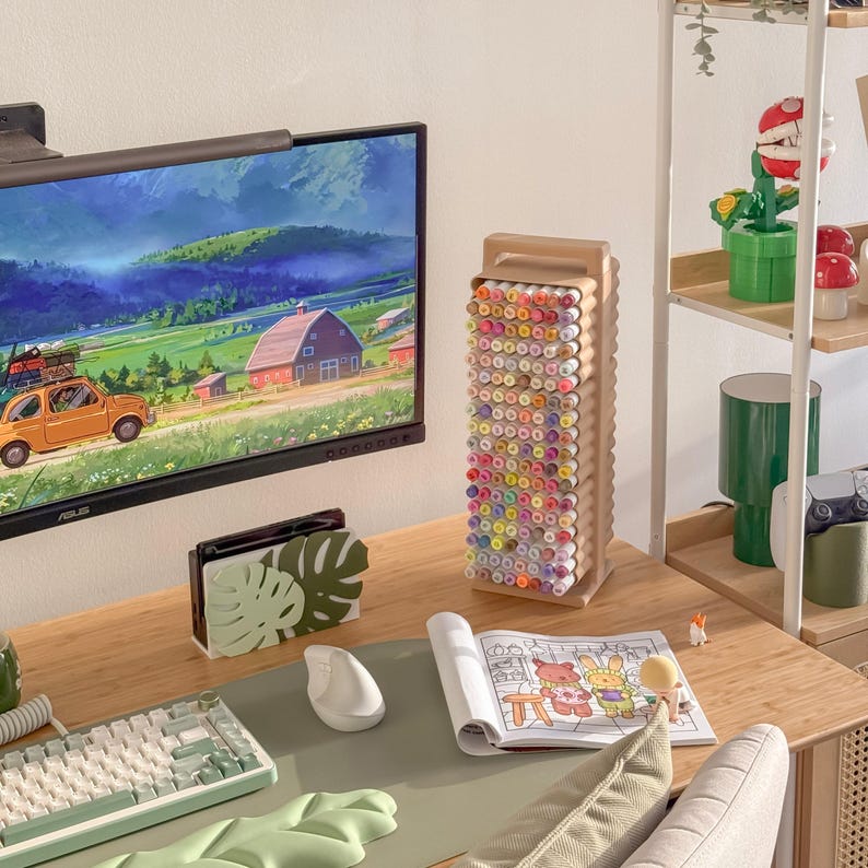May include: A wooden desk with a computer monitor, keyboard, and mouse. A wooden marker holder is filled with colorful markers. A coloring book is open, and a small figurine is nearby. The scene is well-lit and organized.