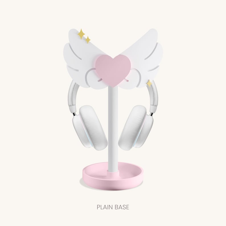 May include: White headphone stand with a pink heart and wings. The base is pink and the stand is white. The text "PLAIN BASE" is printed below the stand.