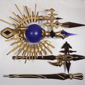 May include: Three decorative golden staffs with purple and black accents. The staffs feature a sunburst design, a sphere, and a pointed tip.