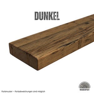 Peut inclure: Une planche en bois rectangulaire avec une finition brun fonc&eacute; et une texture de grain de bois visible. Le mot DUNKEL est imprim&eacute; en gris au-dessus de la planche, et le logo WOODENPOXY est en bas &agrave; droite avec le texte Farbmuster - Farbabweichungen sind m&ouml;glich.