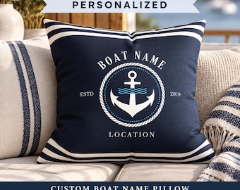 Könnte beinhalten: Ein quadratisches marineblaues Kissen mit weißen horizontalen Streifen oben und unten. In der Mitte befindet sich eine weiße Ankergrafik in einem seilartigen Kreis mit dem aufgedruckten Text BOAT NAME, ESTD 2019 und LOCATION.