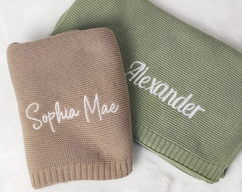 May include: Two knitted baby blankets, one in a light brown color with the name "Sophia Mae" embroidered in white, and the other in a light green color with the name "Alexander" embroidered in white.