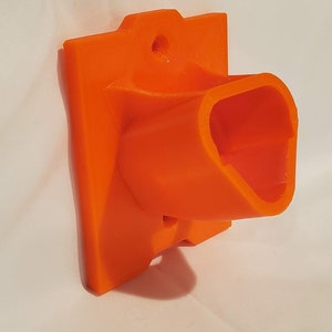 Op de afbeelding: Oranje plastic wandbevestiging met een rechthoekige basis en een gebogen, open gleuf. De bevestiging heeft een gat voor een schroef of spijker.