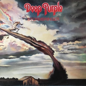 May include: A vintage album cover for Deep Purple's album "Stormbringer". The cover features a white horse with rainbow wings flying through a dark, swirling cloud formation against a cloudy sky.