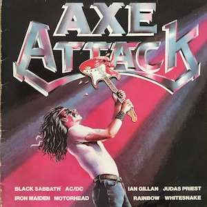May include: A magazine cover with the title "AXE ATTACK" in large, silver letters. A man with long, dark hair is shown playing a red electric guitar. The cover also lists the names of several rock bands, including Black Sabbath, AC/DC, Iron Maiden, Motorhead, Ian Gillan, Judas Priest, Rainbow, and Whitesnake.