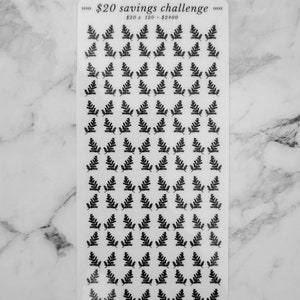 May include: A sheet of clear stickers with black fern leaf designs. The sheet has the text "&pound;20 savings challenge" and "&pound;20 x 120 = &pound;2400" printed on it. The bottom of the sheet has the text "do it for your future self".