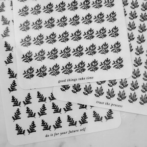 May include: Three sheets of clear stickers with black leaf designs. The top sheet has the text "good things take time". The middle sheet has the text "trust the process". The bottom sheet has the text "do it for your future self".