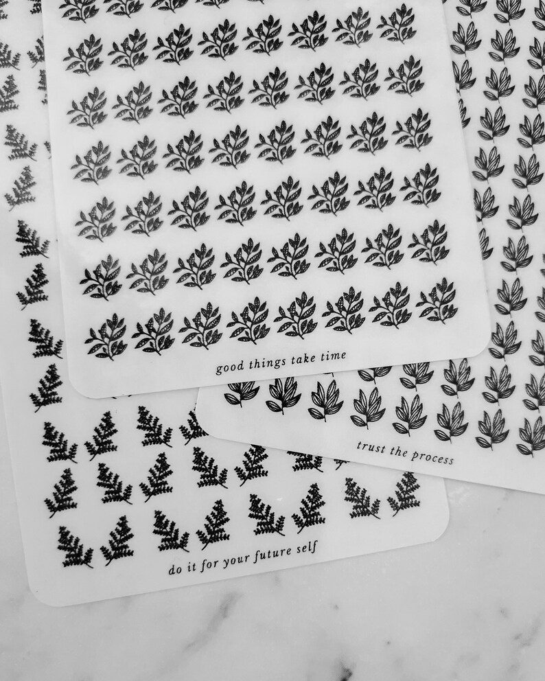 May include: Three sheets of clear stickers with black leaf designs. The top sheet has the text "good things take time". The middle sheet has the text "trust the process". The bottom sheet has the text "do it for your future self".