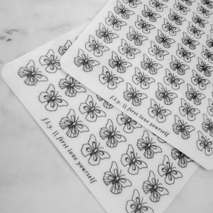 May include: Two sheets of clear sticker paper with black butterfly outlines. The text "fly. || first love yourself" is printed on each sheet.