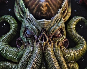 May include: A green and red 3D printed wall sculpture of a Cthulhu-like creature with tentacles. The creature has a large head with a dome-shaped top and a pair of eyes. The sculpture is mounted on a black background.