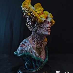 May include: A detailed bust of a Clicker from The Last of Us, featuring a grotesque, fungal-covered head and exposed flesh. The sculpture is painted with realistic colors and textures, mounted on a black base. The Final Product logo is visible.