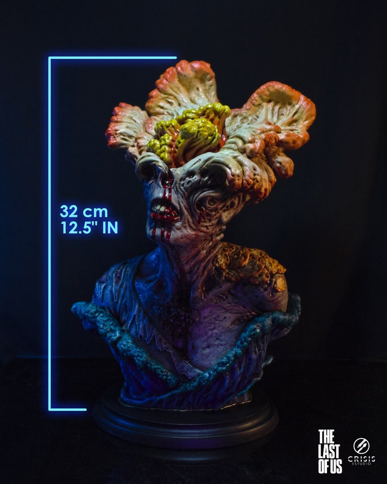 May include: A detailed bust of a creature from "The Last of Us" video game, featuring a grotesque, fungal-covered head and chest. The sculpture is approximately 12.5 inches (32 cm) tall, with a dark base and intricate paintwork. The bust has a dark background.